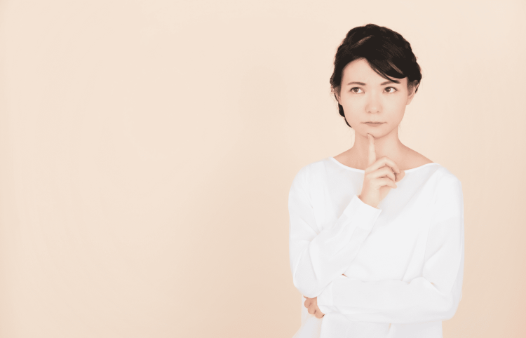 顎に手を当てて考え込む女性